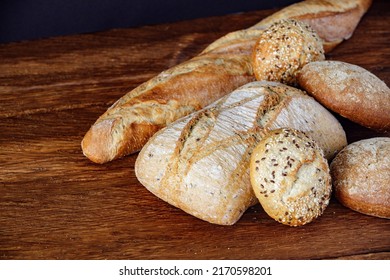 Assorted different types of bread on a wooden table, top view