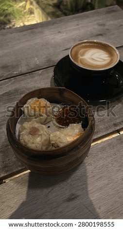 Assorted Dim Sum in Bamboo Steamer Served with Hot Caffe Latte on Wooden Table