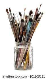 Assorted dirty painting brushes in glass flask