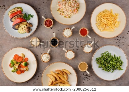Assorted dishes: grilled vegetables, rice with vegetables, french fries, steamed vegetables, country style potatoes, steamed green beans.