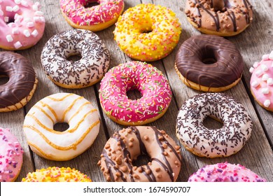 assorted donuts with chocolate frosted, pink glazed and sprinkles . Top view