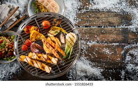 Assorted Farm Fresh Vegetables Grilling On A BBQ Outdoors In Winter Snow With Halloumi Or Bean Curd Kebabs For A Healthy Vegetarian Diet