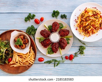 Assorted fastfood Buffalo Mid Joint Wings, loaded Cheesy Fries, Meatballs with chips Served in dish isolated on wooden table top view fastfood