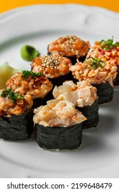 Assorted Four Types Of Gunkan. On A White, Round, Ceramic Plate, There Are Gunkan With Tuna Tartare, With Crab Meat, With Salmon Tartare, Gunkan With Scallop. Each Gunkan Has Two Pieces.