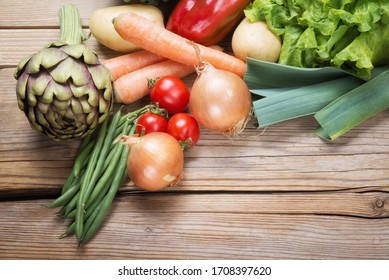 Assorted fresh vegetables on wooden background, top view, space for text.