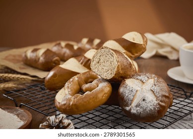 Assorted freshly baked pretzel bread rolls and sliced loaves on a cooling rack with a warm rustic bakery setting.