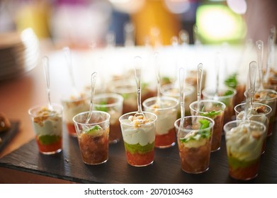 Assorted Fruit Parfait Desserts Served In Plastic Cups With Spoons During Banquet In Restaurant