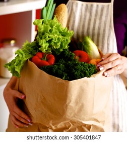 Assorted Fruits And Vegetables In Brown Grocery Bag Holding A Young Girl