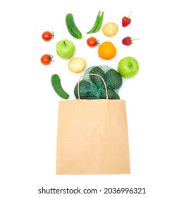 Assorted Fruits And Vegetables Falling Into A Craft Paper Shopping Bag Isolated On White. Creative Organic Groceries Flat Lay.