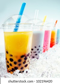 Assorted Fruity Boba Tea Cocktails in a row on crushed ice