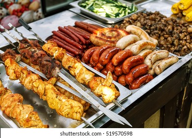 Assorted German sausages grilled in a steel container. Street food market