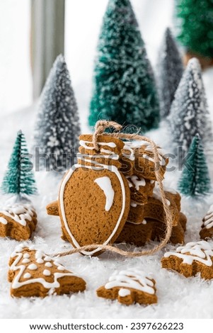 Assorted gingerbread cookie shapes with a festive tree light shape in front.