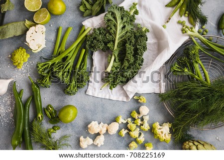 Assorted green vegetables kale leaves tenderstem broccoli peppers cauliflowers pea dill onion asparagus spring vegetables overhead