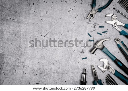 Assorted Hand Tools Laid Out on concrete background, top view with space for text