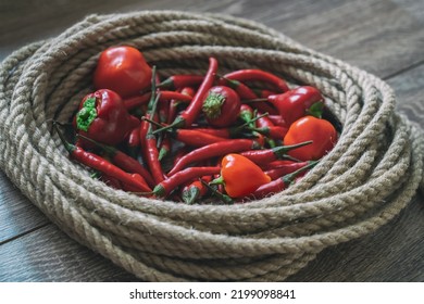 Assorted Hot Peppers Red, Fresh In The Center Of A Rope Circle Close-up