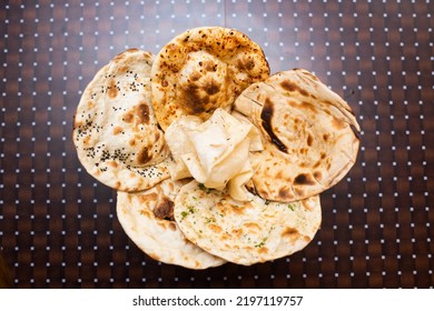 Assorted Indian Bread Basket, Sada Roti, Butter Naan, Garlic Naan, Tandoori Roti And Paratha Served In A Basket Isolated On Table Background Top View Of Bangladesh Food