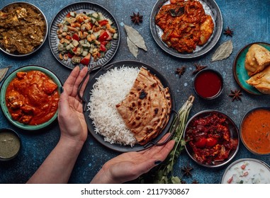 Assorted Indian Ethnic Food Buffet On Rustic Concrete Table From Above: Curry, Fried Samosa, Rice Biryani, Dal, Paneer, Chapatti, Naan, Chicken Tikka Masala, Traditional Dishes Of India For Dinner