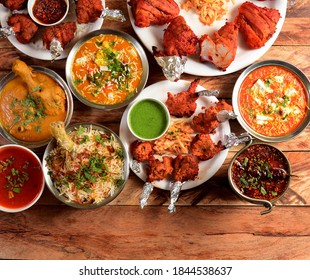 Assorted indian foods chicken biryani,chicken korma,chicken lollipop, paneer butter masala and tandoori chicken on wooden background. Dishes and appetizers of indian cuisine