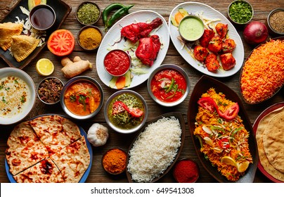 Assorted Indian recipes food various with spices and rice on wooden table