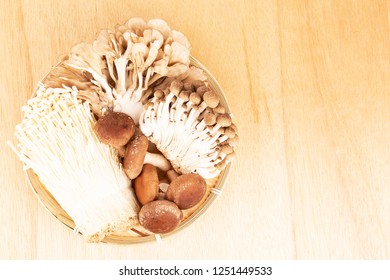 Assorted Japanese Mushrooms Shimeji, Shiitake, Maitake, Enokitake In A Bamboo Plate On Wooden Background. Flat-lay, Top View.