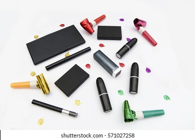 Assorted makeup items. Assorted makeup items arranged with party decorations on a white background