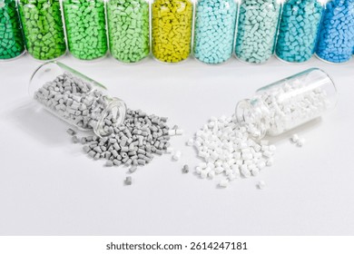 Assorted masterbatch granules in glass bottle, isolated on white background. Color pigment carrier polymer in plastic industry. Perfect for plastic company catalog design