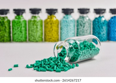 Assorted masterbatch granules in glass bottle, isolated on white background. Color pigment carrier polymer in plastic industry. Perfect for plastic company catalog design