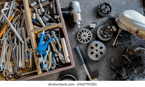 Assorted mechanical tools and car parts scattered on a grungy workshop floor, ideal for automotive repair and maintenance concepts with copy space - Powered by Shutterstock