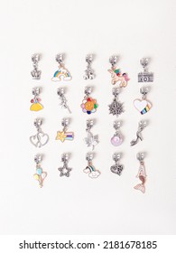 Assorted metal charms for bracelets on white background. Mermaid, heart, snowflake, heart. Creating jewelry - Shutterstock ID 2181678185