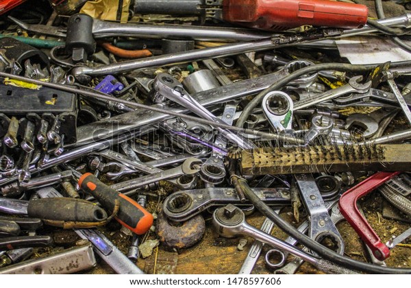 Assorted metal mechanics tools on a work bench,\
selective focus