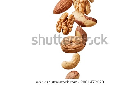 Assorted mixed nuts including walnuts almonds cashews and brazil nuts falling