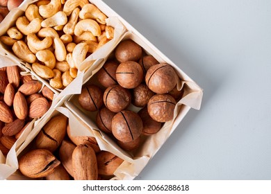 Assorted nuts in a wooden box nuts: pecan, almond, macadamia, brazil, cashew, hazelnut, Rich in minerals and protein. Healthy nutrition, high in zinc, magnesium and vitamins, online ordering, shoping  - Shutterstock ID 2066288618