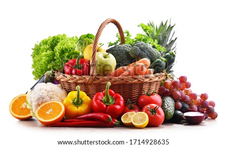Assorted organic vegetables and fruits in wicker basket isolated on white background.