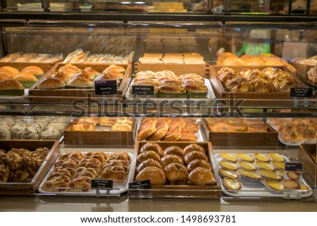 Assorted pastry and bread arranged on tray at bakery shop.