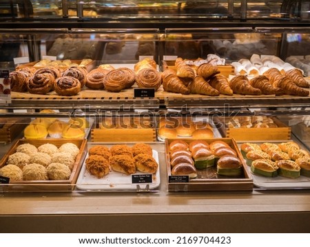 Assorted pastry and bread arranged on tray selling at bakery shop.