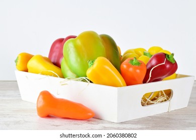 Assorted Peppers In A White Wooden Box, Light-colored Base And Bottom.