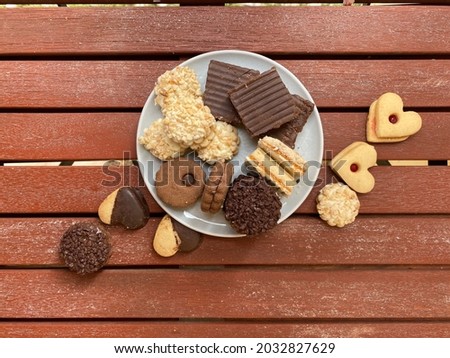 Assorted Petit Four cookies stuffed with  chocolate and garnish on wooden background