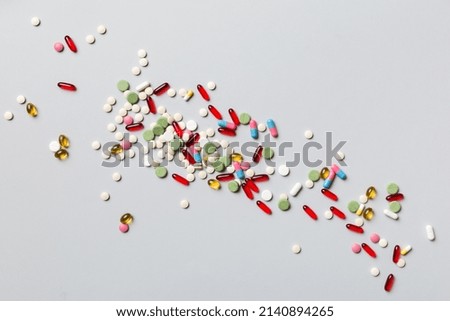 assorted pills and tablets top border over colored background. Many different pills and space for text on colorful background, top view.
