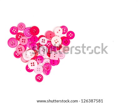Assorted pink buttons in shape of heart on white background