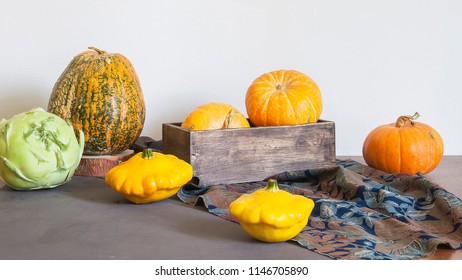 Assorted pumpkins and squashes on rustic wooden boards with an shinning autumn backdrop