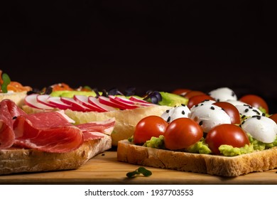 Assorted Sandwiches With Fish, Cheese, Meat And Vegetables Lying On The Board.