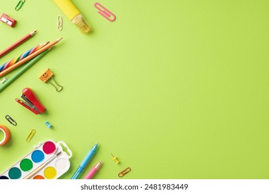 Assorted school supplies including pencils, pens, and paper clips on a light green background. Ideal for back to school themes - Powered by Shutterstock