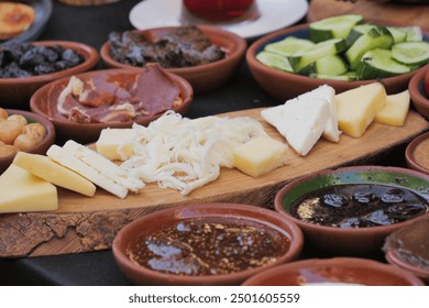 An Assorted Selection of Cheese and Delectable Delicacies Presented on a Wooden Board