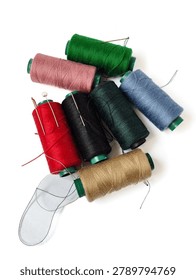 Assorted Sewing Thread Spools with Needles and Pins on White Background