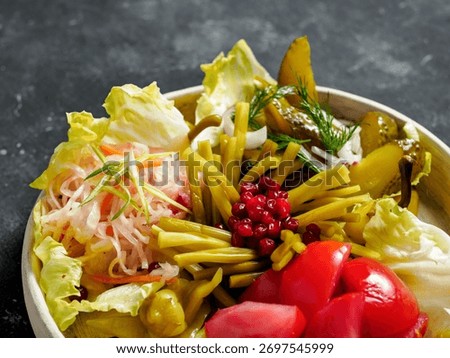 Assorted snacks from fermented cabbage, cucumbers and tomatoes, green bean. Decorated cranberry. Fermented healthy food concept. Pickled cucumbers, marinated tomatoes. Close up