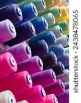 Assorted spools of multi-coloured cotton threads, abstract textile industry background
