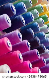 Assorted spools of multi-coloured cotton threads, abstract textile industry background