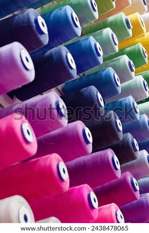 Assorted spools of multi-coloured cotton threads, abstract textile industry background