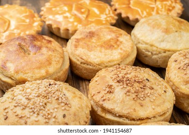 Assorted Stuffed Homemade Pies Over Wooden Table.