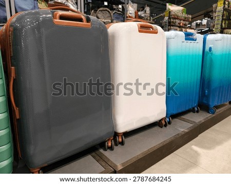Assorted suitcases and backpacks in dark light and blue colors displayed on racks